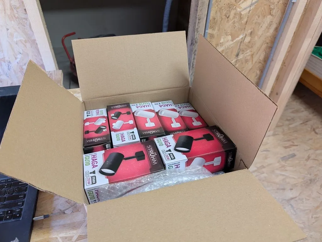 The freshly-delivered track lights, still in their original packaging.