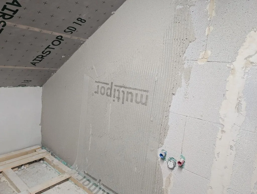 The beginning of the base coat, which is embedded in a fiberglass mesh, like for a classic lime-cement render finish.