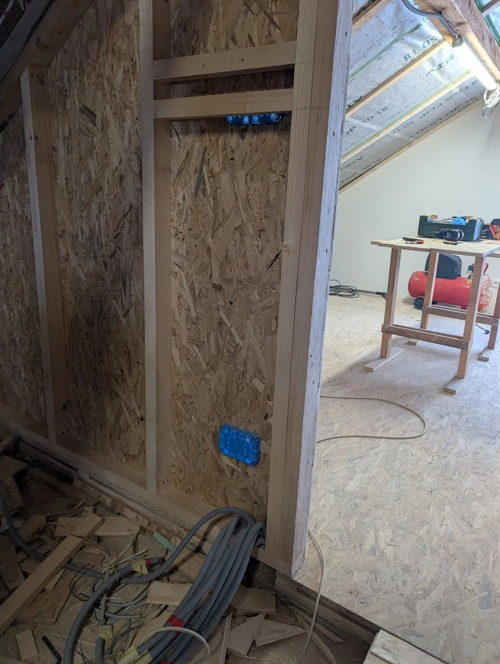The two pieces of horizontal blocking in the stud wall will hold the electrical panel. Cable enters from below—you can see the collection of conduit at the base of the wall.