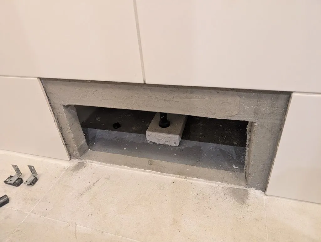 The hole in the wall for accessing the bathtub plumbing, which will be covered by a blind tile.