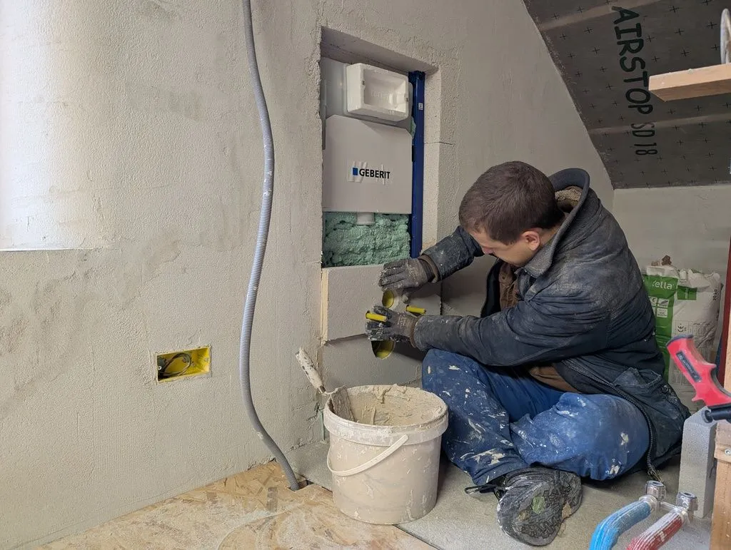 Fitting the blocks over the protruding plumbing and mounting brackets.