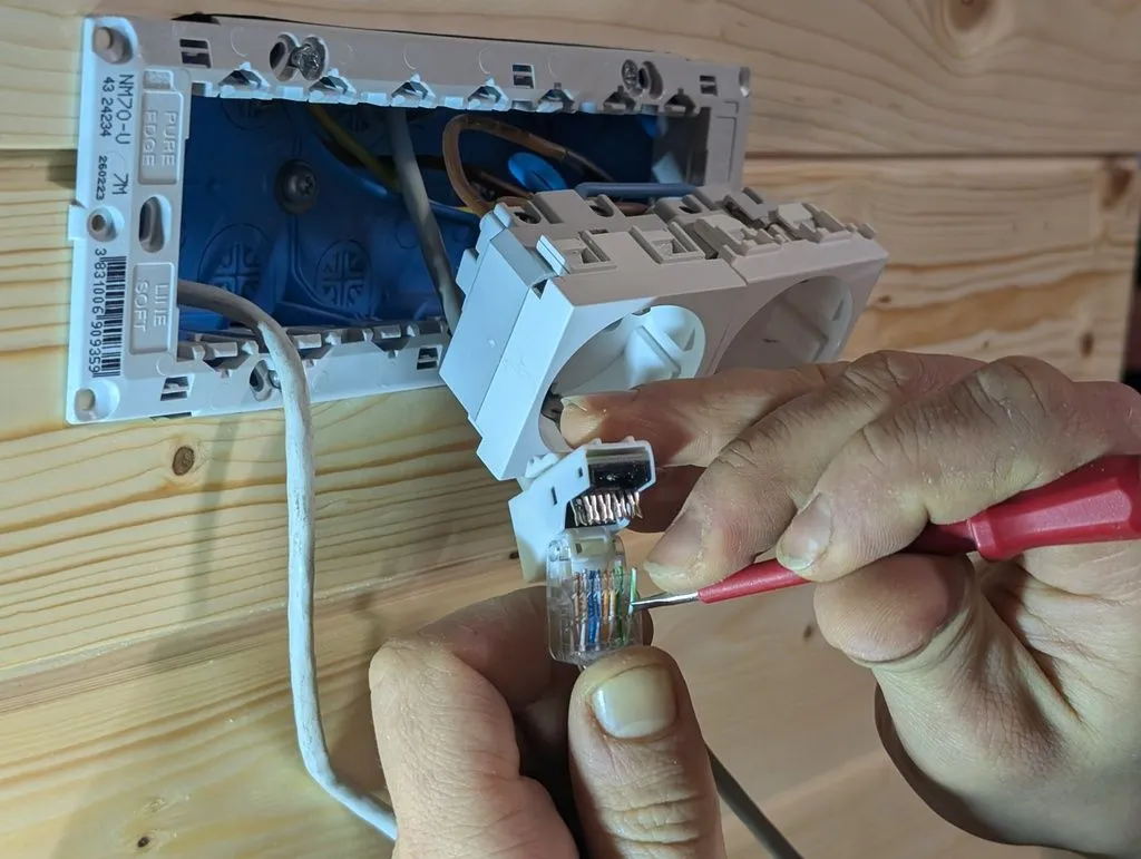 The Ethernet jacks have terminals for each of the eight conductors in standard Ethernet cable. Here I'm using a fine screwdriver to insert the conductors into their terminals.