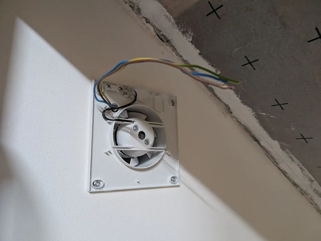 The fan's mounting frame attached, with wiring routed in.
