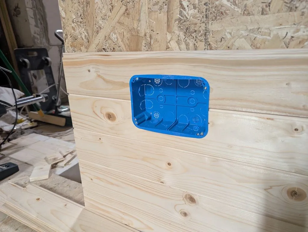 The box is held in place by mounting clips at the back, which are tensioned with screws at the front of the box to accommodate walls of varying thickness.