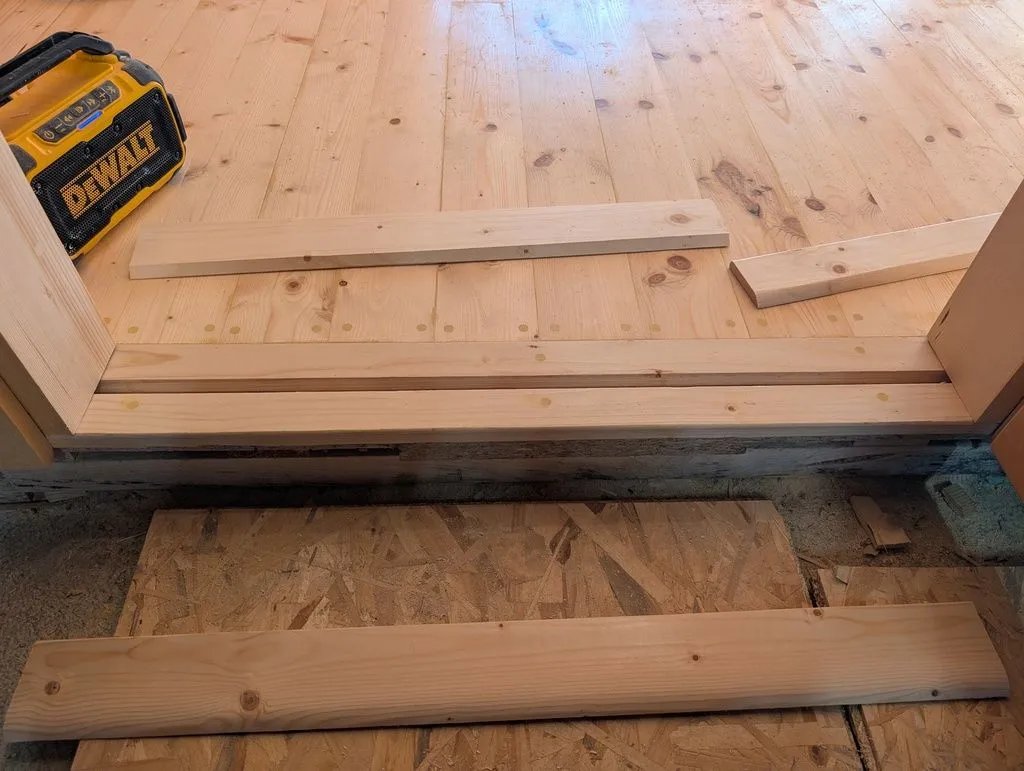 The first piece of the threshold, which would entirely span the gap in the floor, ready for installation.