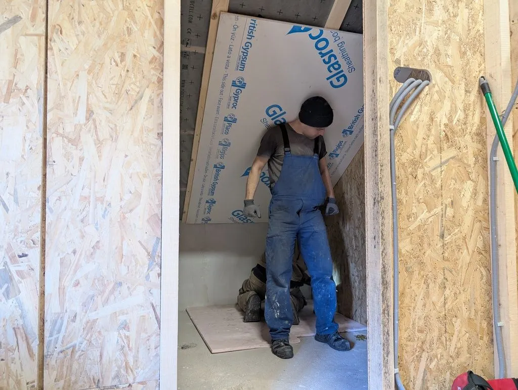 Holding up the first board of ceiling drywall with my back while my cousin Anže, who once again came to rescue, attaches the board below.
