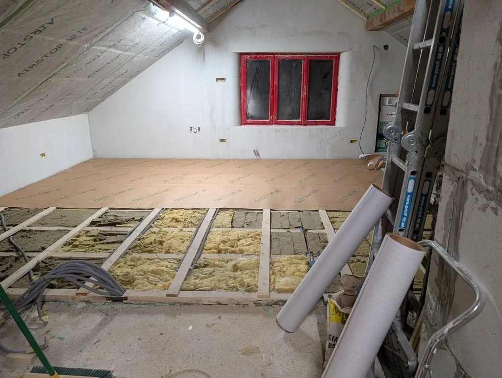 We added a layer of heavy-duty construction paper over the insulation to contain the glass wool, and as an underlayment for the subfloor.