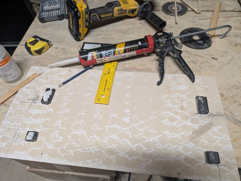 Attaching the magnets to the back of the tile with a water-resistant construction adhesive.