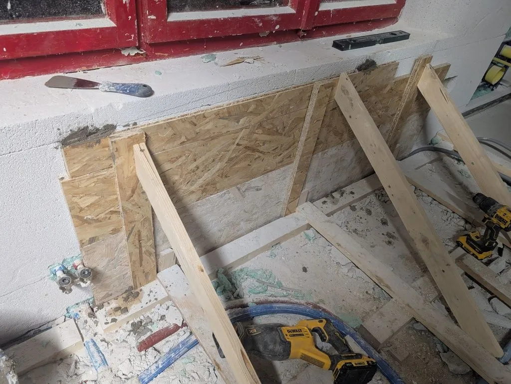 The forms holding the concrete, made of OSB with bracing fastened to the wooden sleepers in the subfloor's substructure.
