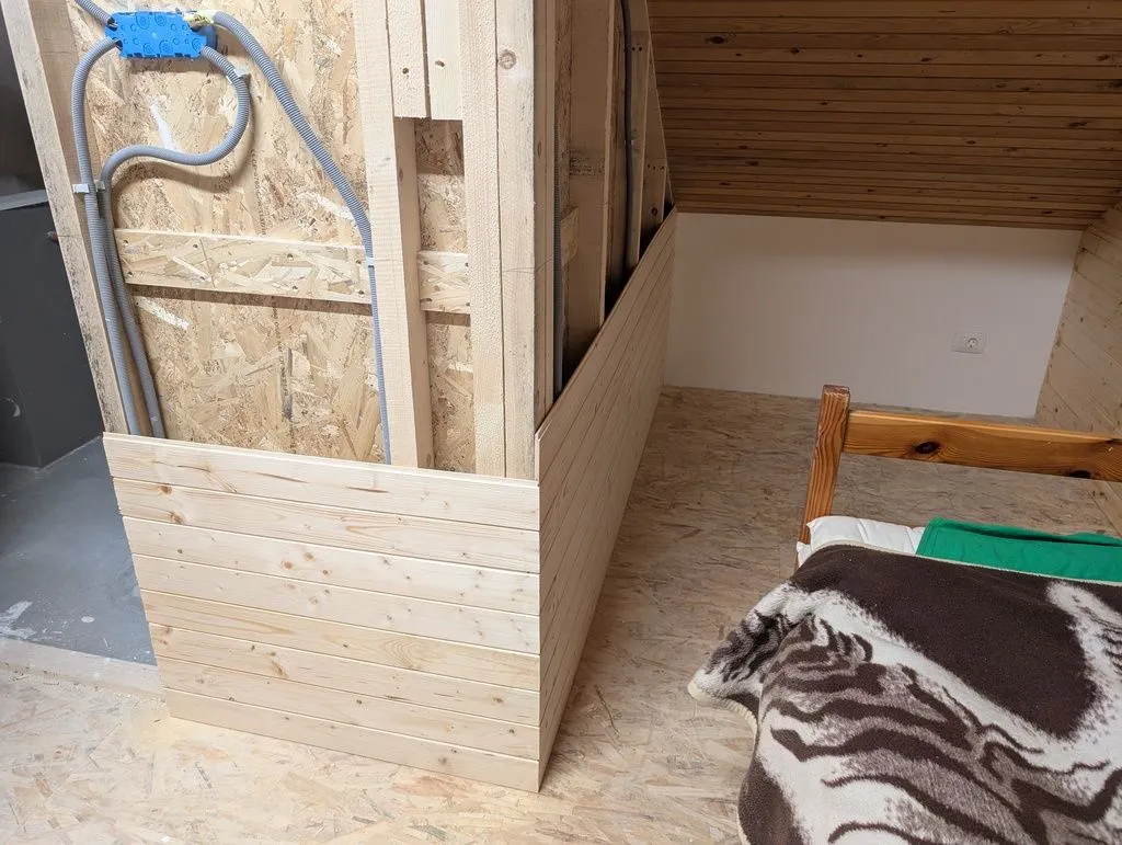 Attaching the tongue and groove finish to the exterior of the bathroom walls. At this point I had also installed the electrical box (blue box in top left) holding the bathroom light switches and outlets.