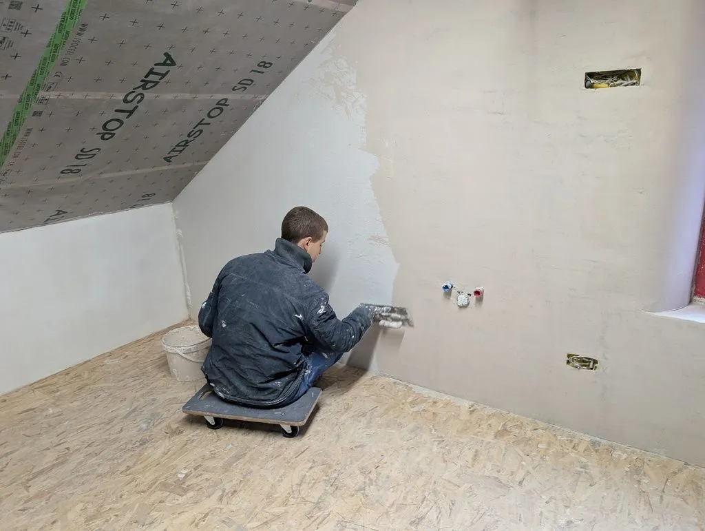 Trowelling on the finish coat—the transport dolly makes for a convenient mobile chair.