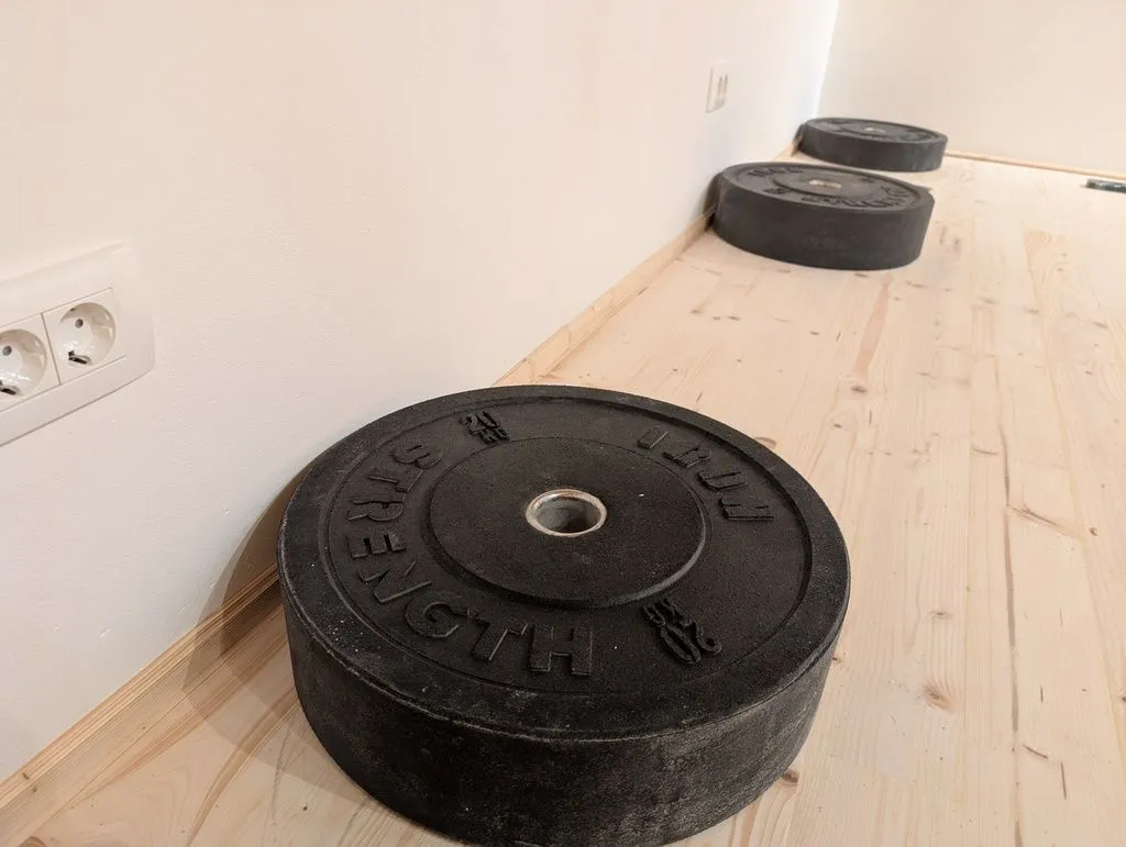 Using weights to hold the baseboards in place while the adhesive cures.