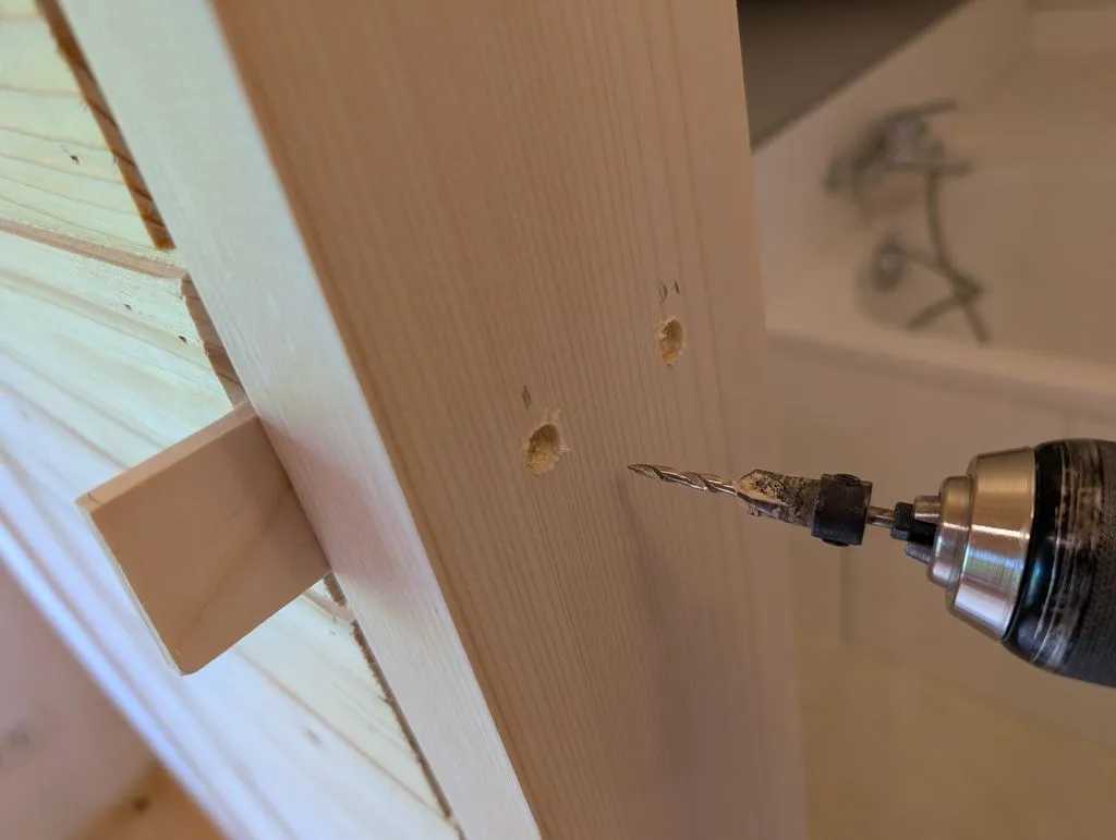 Attaching the side jambs—we used countersunk construction screws, and later filled the screw holes with wood filler.