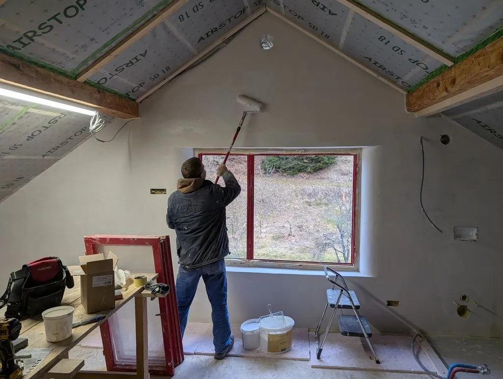Painting the wall—the roller and extension pole come in handy for the high areas.