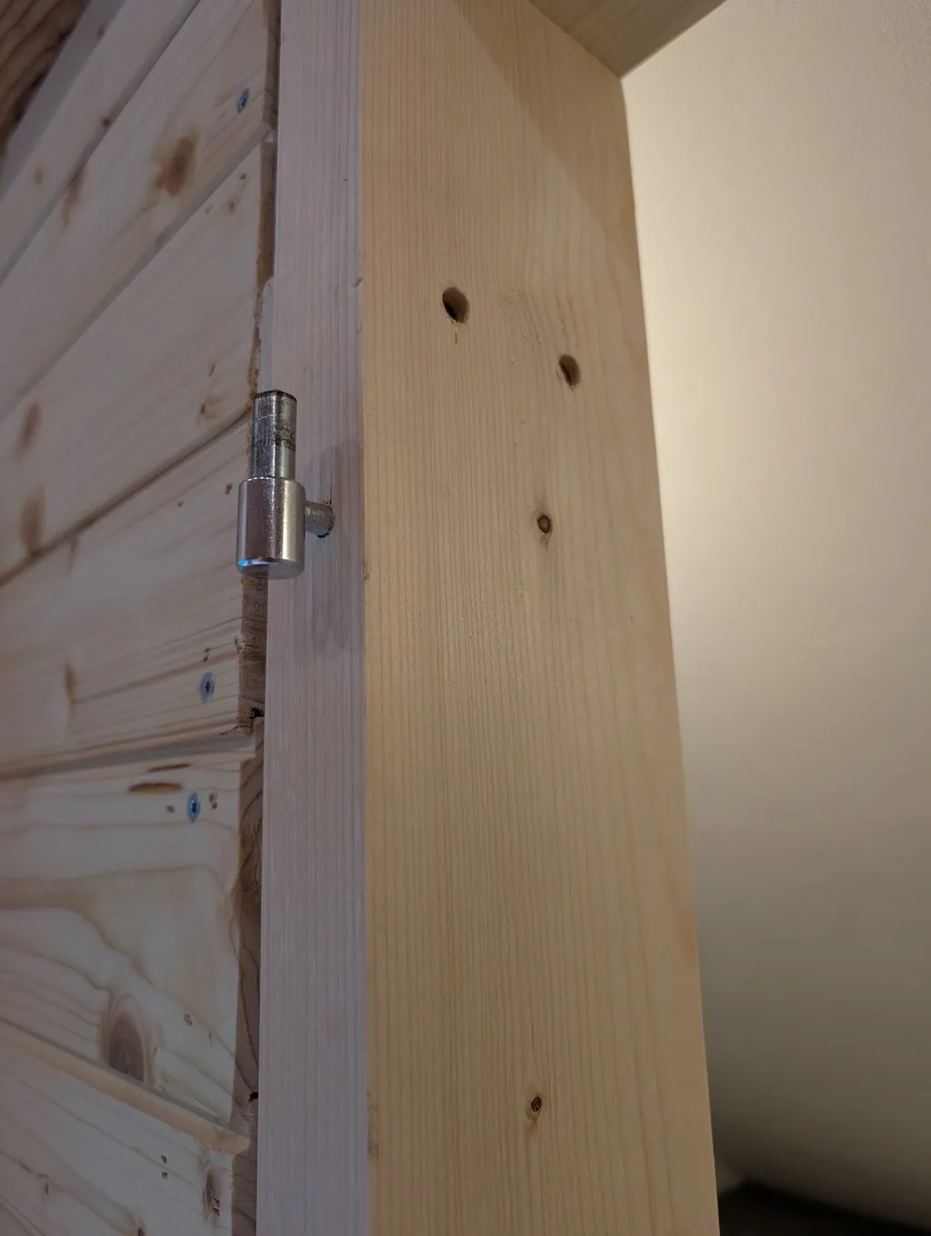 Attaching the hinges to the jambs. Matching hinges on the door fit over and pivot on the pin hinges in the jambs. These hinges are simple and don't allow any adjustment, so they have to be accurately placed.