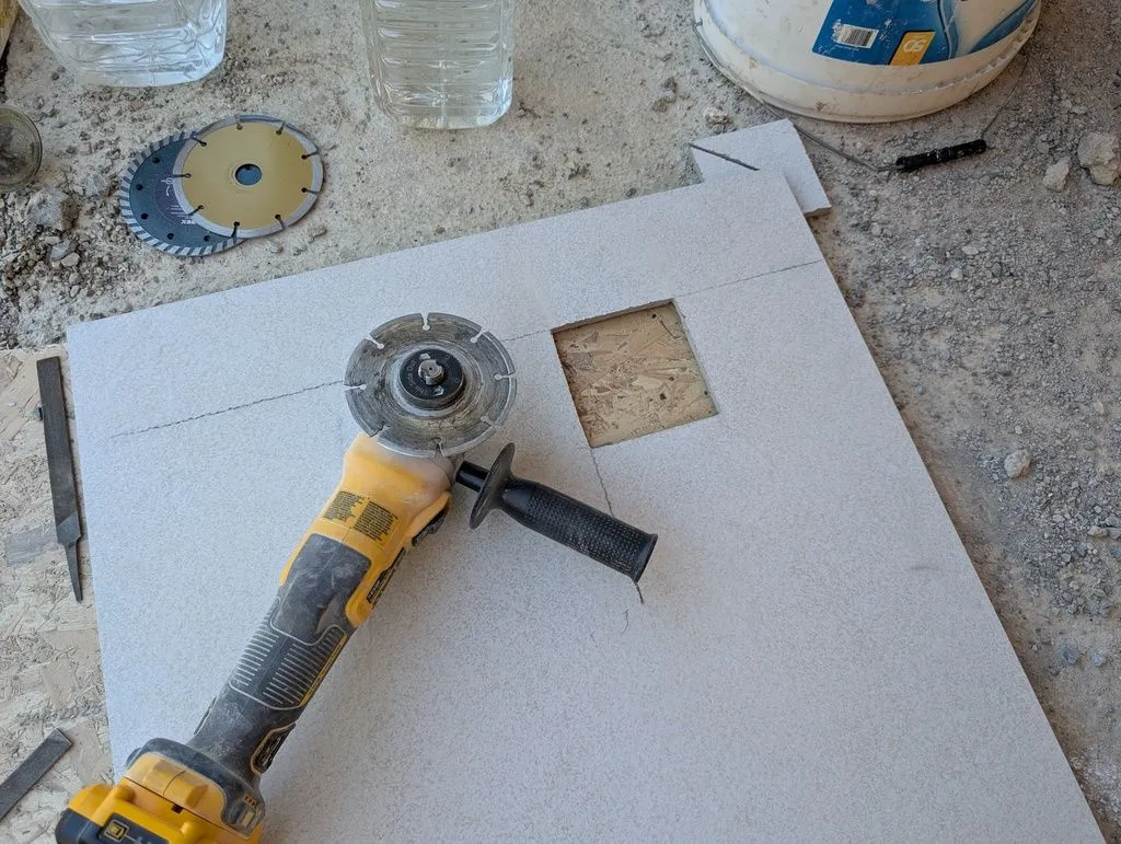 The opening for the hole drain, cut with a diamond-tipped cutting disk on the angle grinder. The floor tiles are granite and quite a challenge to cut (the ceramic wall tiles were softer and much easier to cut).