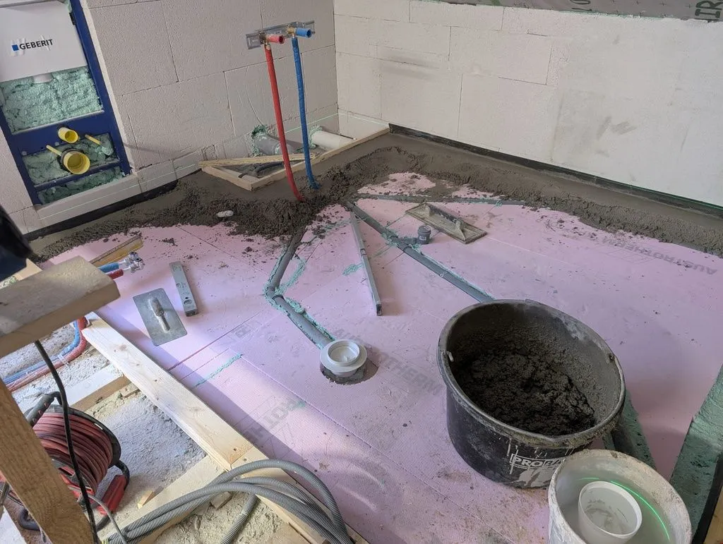 The first of the cementitious screed being laid on top of the XPS. We first establish level around the perimeter, then fill in towards the center.
