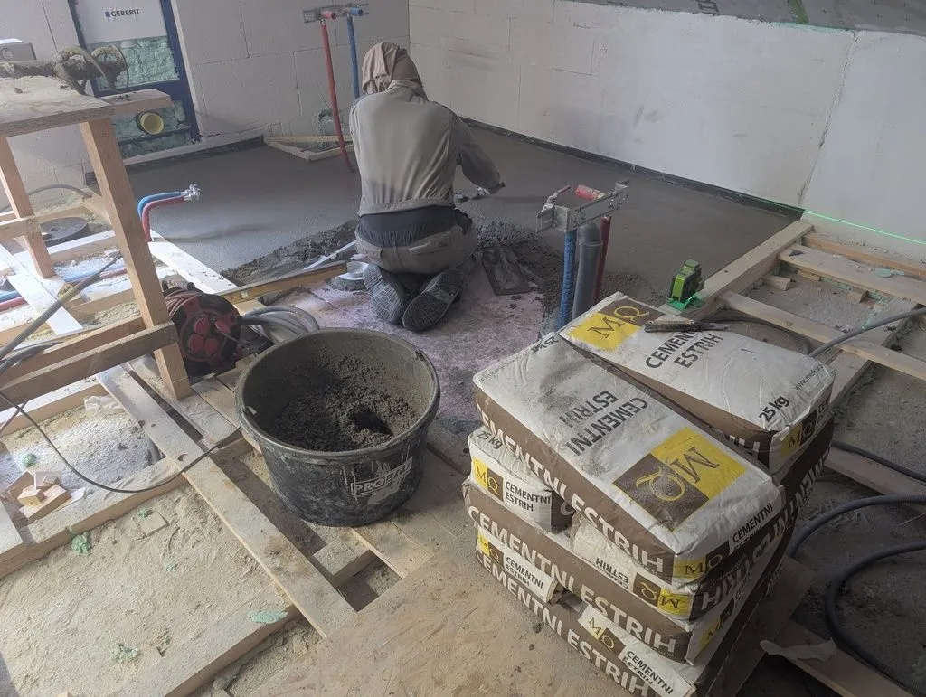 My cousin Anže, who was a crucial help during a few critical phases of the project, including the first phase of bathroom work. Here he is leveling out the screed.
