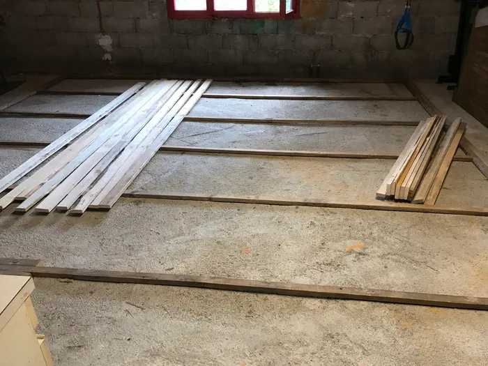 The bottom layer of the sleeper grid (with the soon-to-be-installed second layer of perpendicular slats on top). The assembly was shimmed to level, then covered with OSB panels.