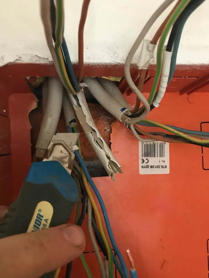 Stripping outer insulation from cables with a utility knife.