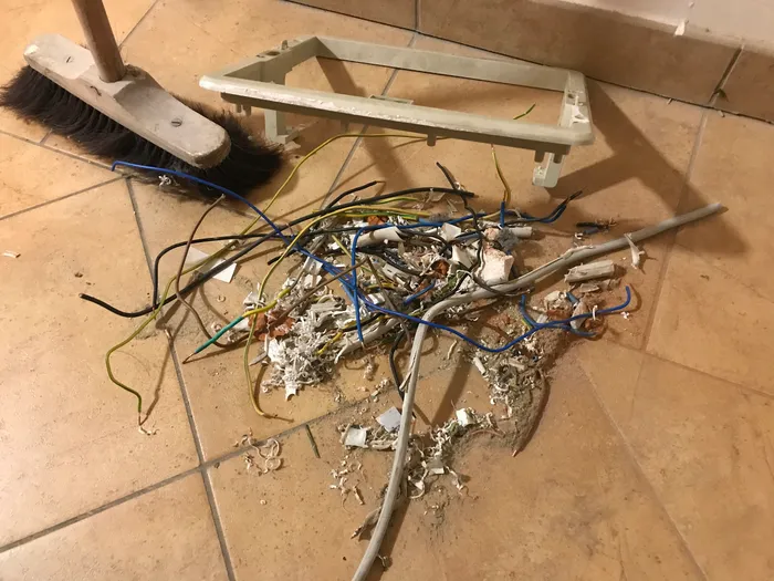 Sweeping up scrap wire, insulation, and other debris.