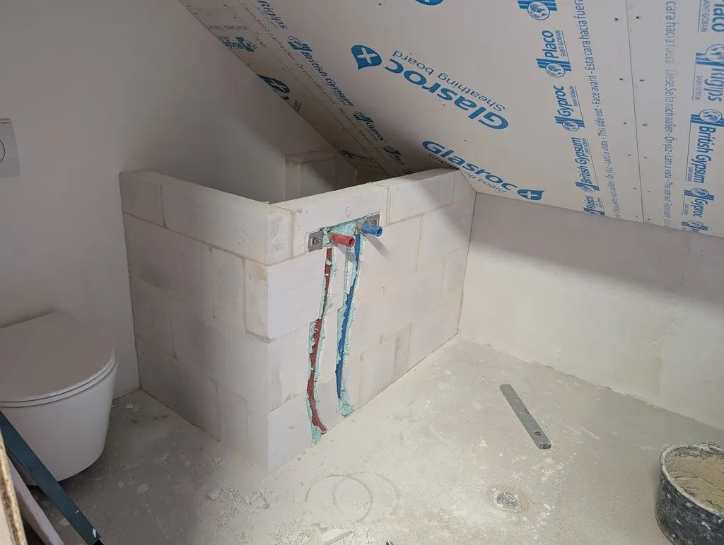 The completed "pony wall" that holds the hot and cold water lines for the bathtub and walls of the plumbing in the back.