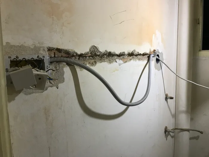 A freshly cut/excavated chase and conduit to supply outlets for a computer.