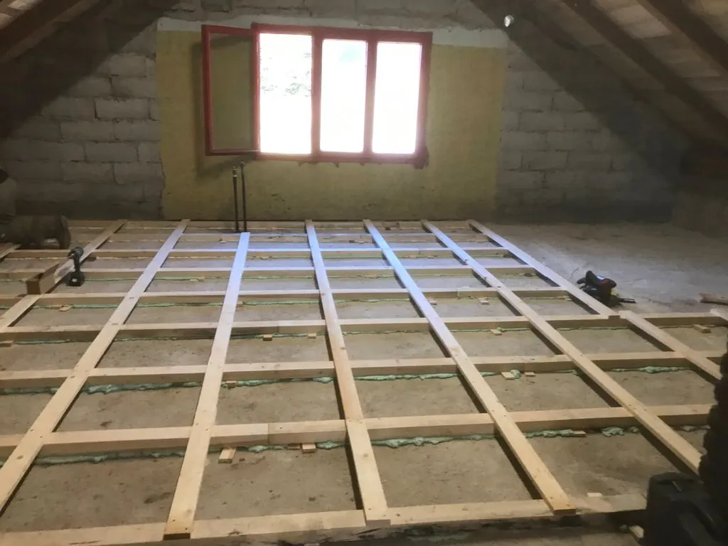 The completed subfloor substructure, with slats placed perpendicularly across the sleepers for added springiness. Spray foam has been added under the sleepers for additional support from below.
