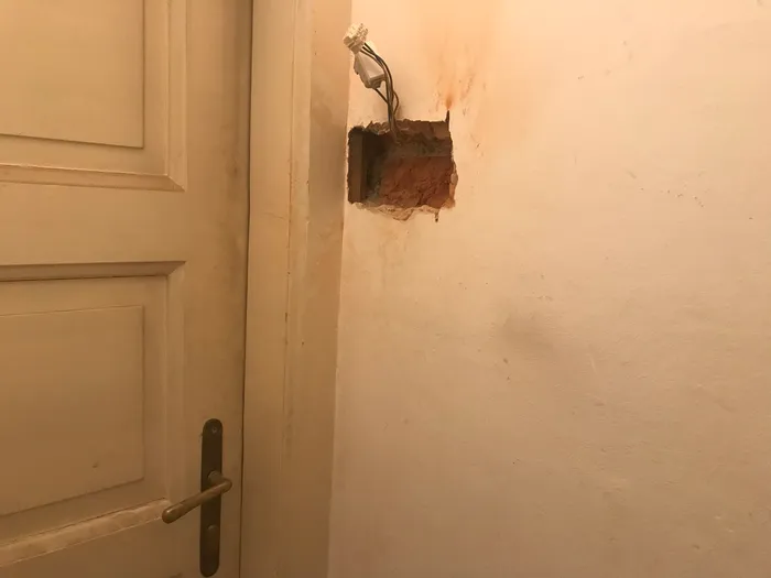 The rectangular cavity hewn out of the masonry wall to hold a new electrical box.